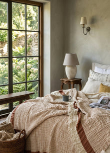 Aurea Muslin coverlet in Clay — lifestyle shot draped over styled bed