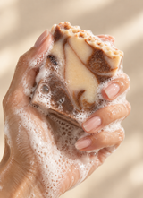 A Calinea cold-process soap bar lathering in hand — rich, soft foam from a handmade Turkish soap